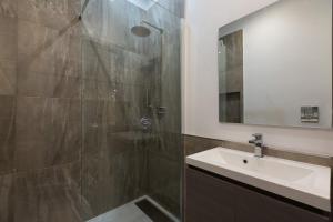 罗马Clementi Portrait的带淋浴、盥洗盆和镜子的浴室