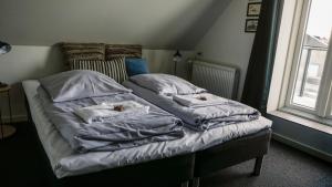 希茨海尔斯B&B by the Sea Hirtshals的一张带两个枕头的床和窗户