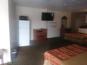 新布朗费尔斯Garden Inn & Suites New Braunfels的酒店客房配有两张床和一台冰箱