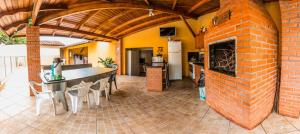 伊瓜苏Hostel Beija flor的开放式厨房和带砖砌壁炉的客厅