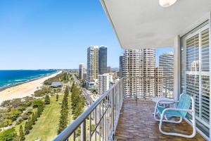 黄金海岸塔利斯曼公寓的一个带蓝椅和海滩的阳台