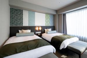 京都Kyoto U-BELL Hotel的一间卧室设有两张床和窗户。