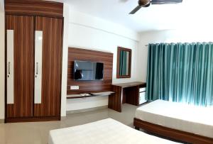 钱德加尔Pride Home的酒店客房设有两张床和电视。