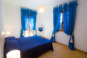 卡波利韦里Villette Luisa by SolturElba的蓝色的床,带蓝色窗帘的房间