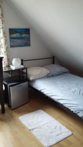韦斯特洛didi logement的一间卧室配有两张床、一张桌子和一张地毯。