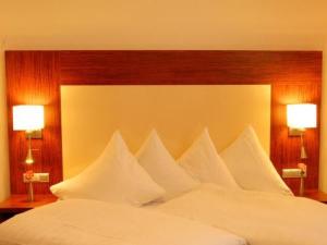 罗德马克斯特科尔酒店的一张带白色枕头的大床和两张台灯
