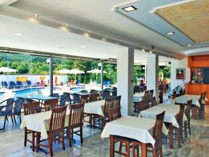 帕拉利亚潘塔利莫诺斯Hotel Afroditi的一间带桌椅的餐厅和一个游泳池