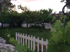 维耶斯泰Kimera Beach Apartments的树木繁茂的院子中的一个白色的栅栏
