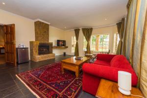 布兰太尔Game Haven Lodge的客厅设有红色的沙发和壁炉
