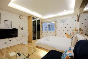 高雄缤纷乐旅店的卧室配有白色的床和电视