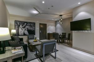 舍地Sun-n-Sand Suites, Shirdi的带沙发和电视的客厅