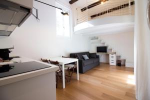 米兰Sant'Andrea cozy apartment的厨房以及带沙发和桌子的客厅。