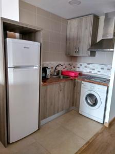马拉加Sunny Beach的厨房配有白色冰箱和洗衣机。