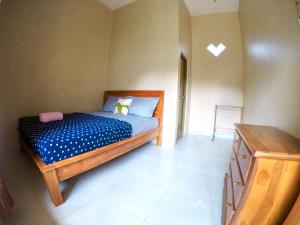卡里蒙贾瓦Asta Homestay的一间卧室配有一张带蓝色棉被的床