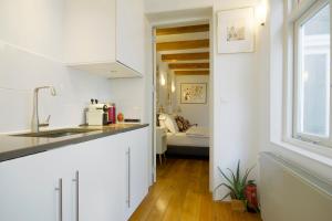 阿姆斯特丹Mercedes Bed&Breakfast Amsterdam的厨房设有白色的墙壁、水槽和窗户