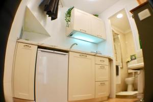 奥帕提亚Amorino Apartman Studio的小厨房配有白色橱柜和水槽