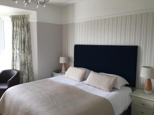 桑德斯富特Woodlands Guest House的一间卧室配有一张大床和蓝色床头板