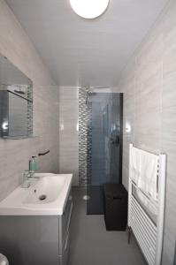 泰恩河畔纽卡斯尔Bentinck Apartments的白色的浴室设有水槽和淋浴。
