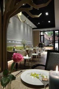 员林枫采时尚汽车旅馆的餐厅设有桌椅和一张桌子上的花朵