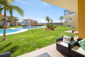 阿尔布费拉Marina Luxury Residence - Albufeira的享有游泳池和草坪的景色。