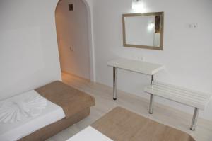 马尔马里斯迈拉酒店的一间卧室配有一张床、一张桌子和一面镜子