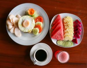 姆杜克巴厘岛拉哈优民宿的餐桌,带两盘食物和一杯咖啡的桌子