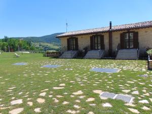 PreciAgriturismo Rocca del Nera的一座房子前面有草地庭院