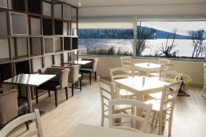 卡斯托里亚帕拉利姆尼奥套房旅馆的餐厅设有桌椅和大窗户。