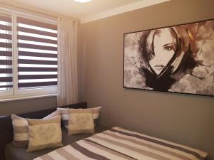 卡尔斯哈根Christel的卧室配有一张床,墙上挂有绘画作品