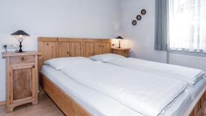 普雷多伊Appartements Respiration Almhaus Pfister的一间卧室配有一张带白色床单的大床