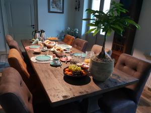 泽弗纳尔Bed & Breakfast Huis Sevenaer的木桌,上面有盆栽植物