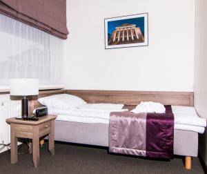 波兹南WILla Medica的一间卧室配有一张床和一张带台灯的桌子