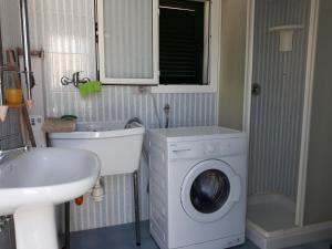 马鲁焦casa gialla mare del salento的一间带洗衣机和水槽的浴室