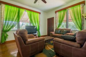 特拉Los Olingos Lodge的客厅配有两把椅子和电视