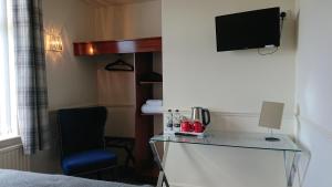 Liversedgegeordie pride lodge的酒店客房配有书桌和电视。