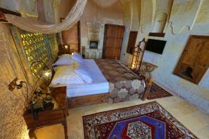 乌奇希萨尔卡帕多西亚之眼洞穴酒店的一间卧室配有一张床和一台电视。