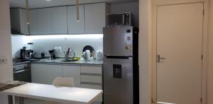 埃斯特角城Vistas的厨房配有不锈钢冰箱和桌子