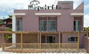 弗洛里亚诺波利斯Pousada Moquirido的粉红色的房子,前面设有木甲板