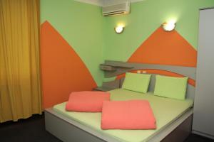 阿塞诺夫格勒彩色酒店的一间设有两张红色枕头的床的房间