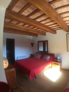 卡达克斯Es volca的一间卧室设有红色的床和木制天花板