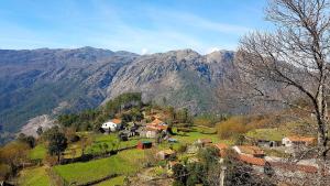 AlamelaCasinha do João no Gerês的山丘上的村庄,以山丘为背景