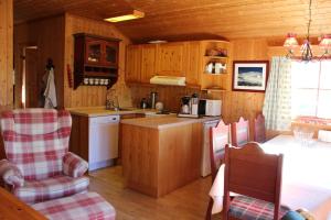 耶卢Ådnebu by Norgesbooking - cabin with 3 bedrooms的厨房配有木制橱柜和桌椅