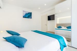 普利兹巴Antea Apartment的一间卧室配有白色床和蓝色枕头