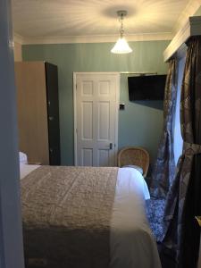 大雅茅斯白色旅馆的卧室配有床和白色门