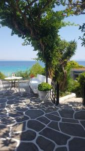 卡利塞亚-豪客迪克斯A beautiful beachfront maisonette的一个带桌椅的庭院和大海