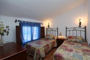 科尼尔-德拉弗龙特拉Albara的一间卧室设有两张床和窗户。