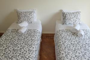 里斯本拜罗度假公寓的配有2张床的带白色床单和枕头的客房