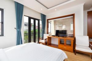 胡志明市阳光酒店和公寓的一间卧室配有一张床和电视