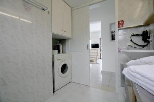 阿尔米里达Ostria Seaside Home的白色洗衣房配有洗衣机和水槽