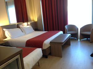 卡尔达诺阿尔坎波马尔彭萨卡达诺酒店的一间酒店客房,设有两张床和电视